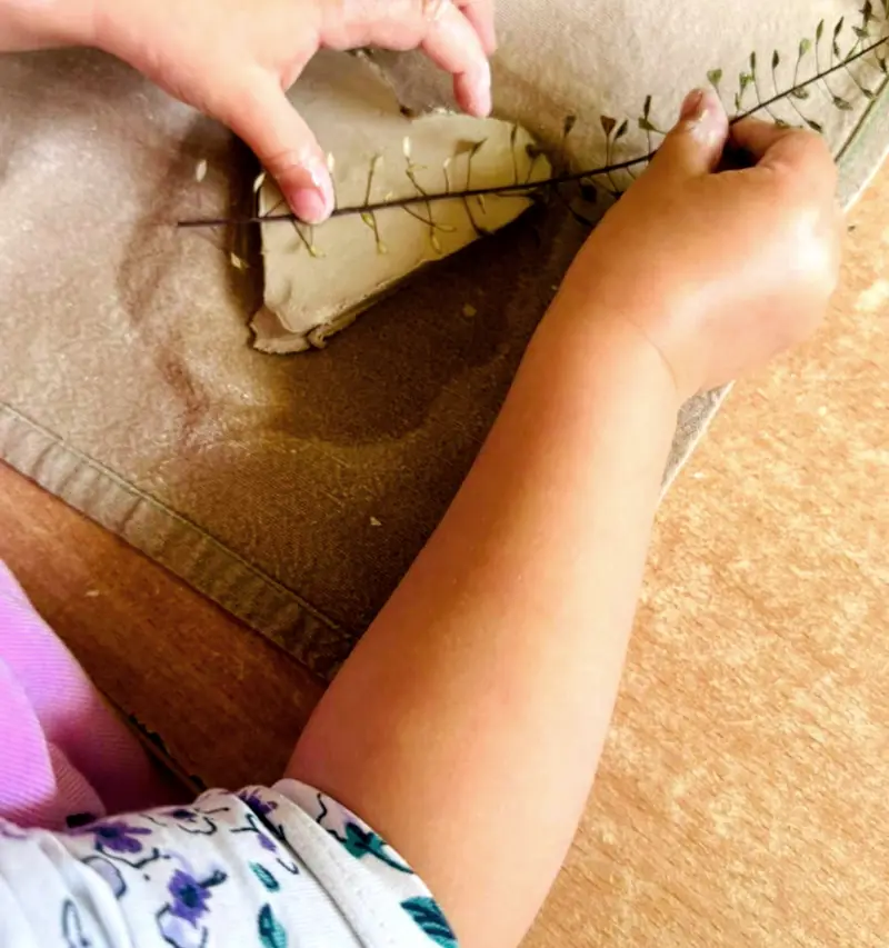 Dziecięce dłonie formują glinę na warsztatach ceramicznych