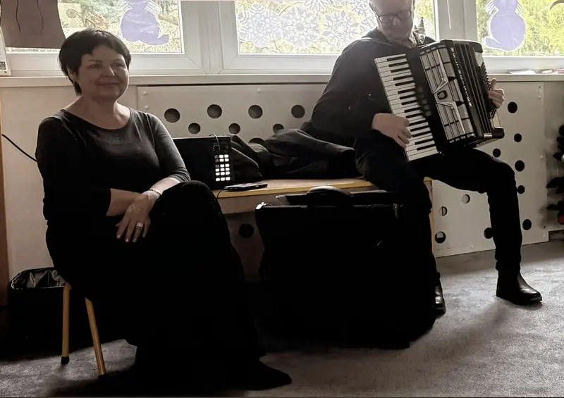 Koncert w sali: muzyk gra na akordeonie